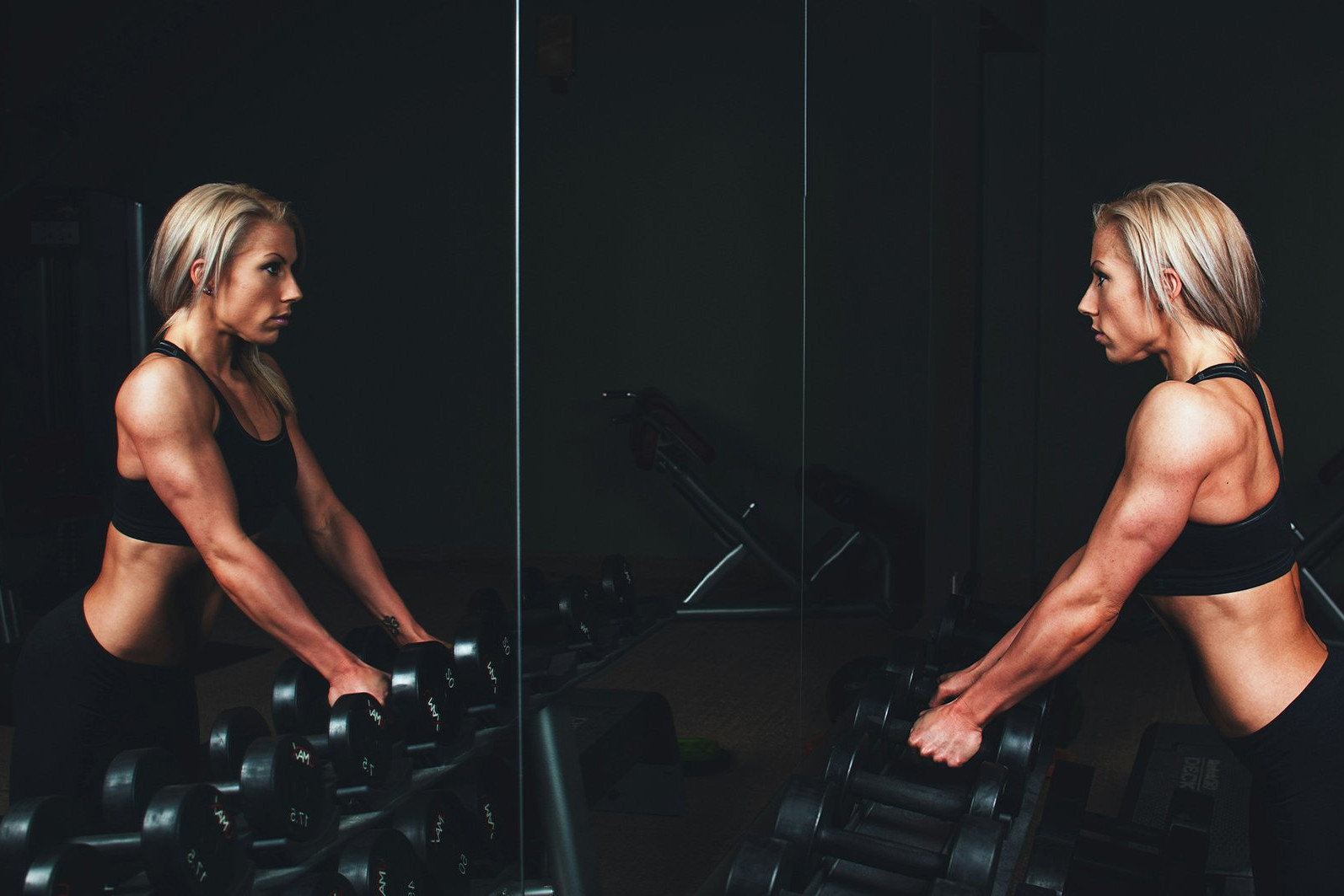 woman lifting dumbbells in gym
