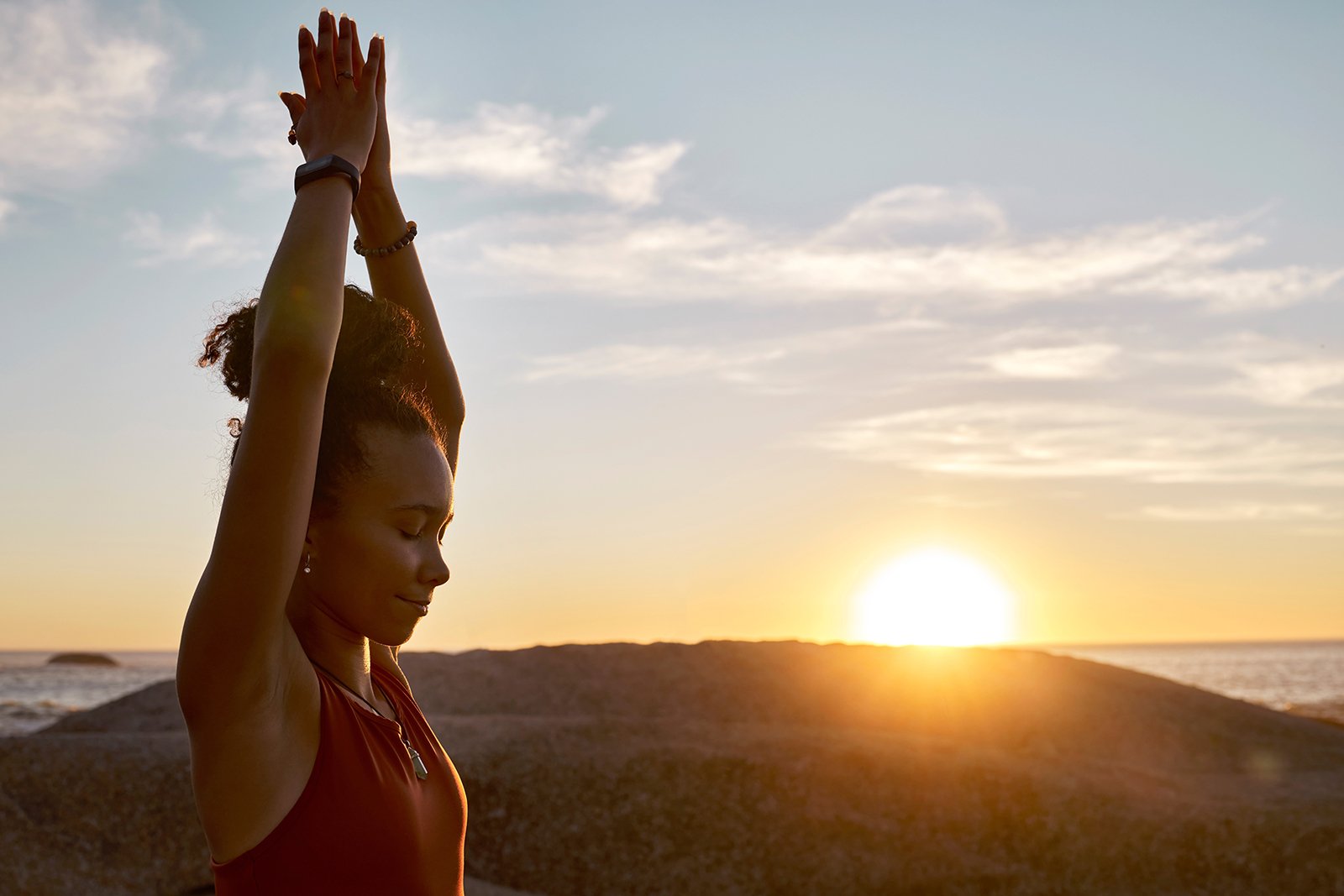 woman stretching at sunset